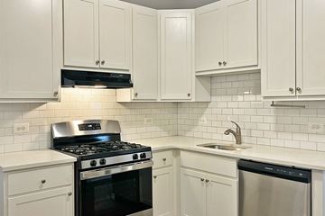 Oak Park apartment for rent - A kitchen with white cabinets and a black stove top.