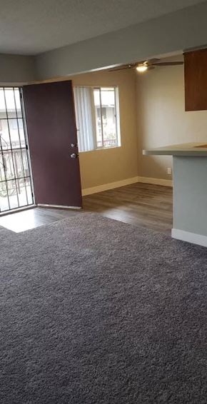 Downey apartment for rent - an empty living room with a door to a balcony