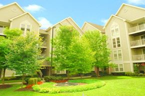Frederick apartment for rent - an apartment building with a green yard and trees