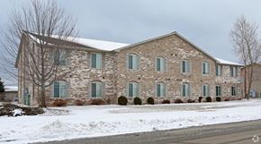 Algoma apartment for rent - a large brick church with green shuttered windows in the snow