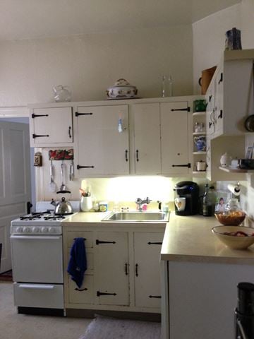 Narberth apartment for rent - a kitchen with white cabinets and a sink and a stove
