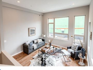 Philadelphia house for rent - A living room with a grey couch and a black and white rug.