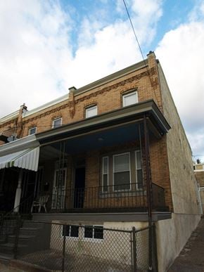 Philadelphia house for rent - A brick building with a balcony and a fence.