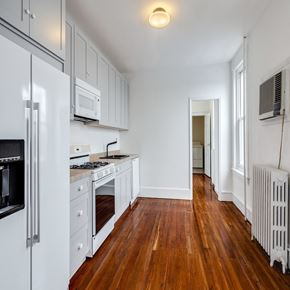 Philadelphia house for rent - A kitchen with white appliances and wooden floors.