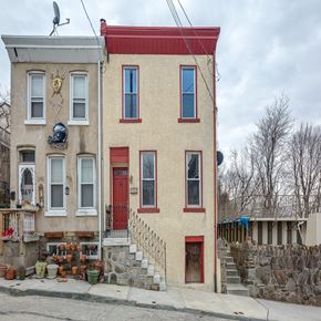 Philadelphia house for rent - A tan house with a red door and a red roof.