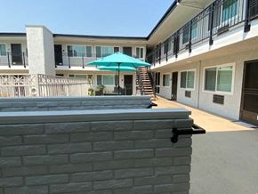Glendale apartment for rent - a patio with an umbrella and a brick wall