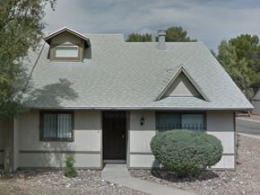 Tucson house for rent - a white house with a gray roof and a bush in front of it