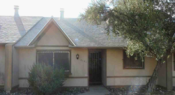 Tucson house for rent - A house with a black door and a small window is shown.