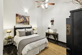 Greenville apartment for rent - A bedroom with a large bed and a painting on the wall.