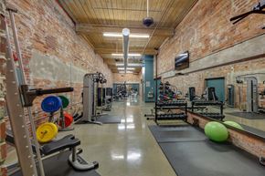 Greenville apartment for rent - A gym with a brick wall and a variety of exercise equipment.