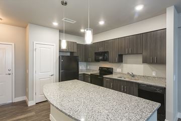 Colorado Springs apartment for rent - a kitchen with granite counter tops and black appliances