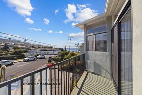Redondo Beach apartment for rent - A balcony overlooks a street with cars and buildings.