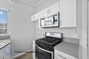 Redondo Beach apartment for rent - A modern kitchen with a stove top oven and microwave above it.