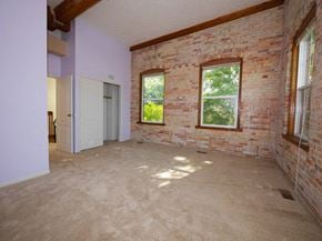 Grand Ledge townhouse for rent - an empty room with a brick wall and two windows