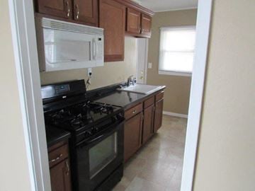 Peoria house for rent - A kitchen with black appliances and wooden cabinets.