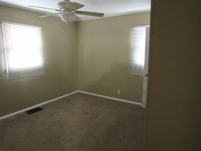Peoria house for rent - A room with a ceiling fan and two windows.
