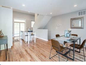 Philadelphia house for rent - A dining room with a table set for two and a kitchen area in the background.