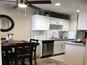 Sparks apartment for rent - a kitchen with white cabinets and a table and chairs