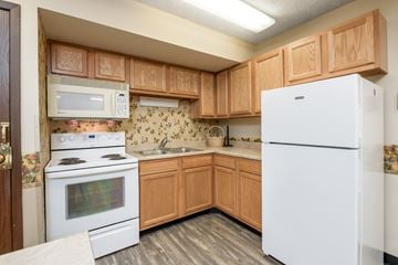 Miamisburg apartment for rent - a kitchen with white appliances and wooden cabinets