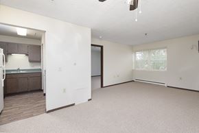 Miamisburg apartment for rent - an empty living room with a kitchen in the background