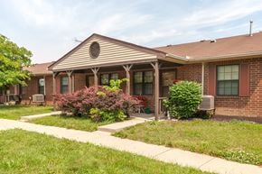 New Lebanon apartment for rent - the front of a brick house with a lawn and sidewalk