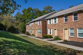 Dayton apartment for rent - a brick apartment building with a sidewalk and grass