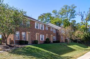 Dayton apartment for rent - a brick house with a lawn and trees