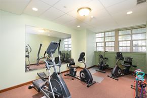 Lorain apartment for rent - the gym has plenty of exercise equipment and a large mirror
