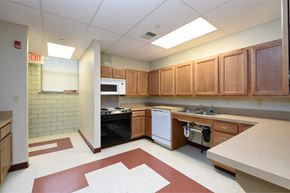 Lorain apartment for rent - an empty kitchen with wooden cabinets and white appliances