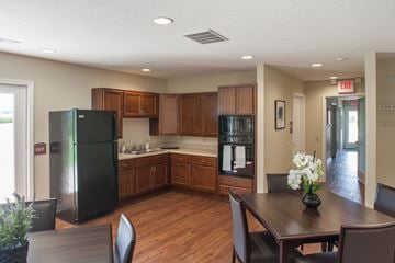 Fostoria apartment for rent - a kitchen with black appliances and a wooden table and chairs