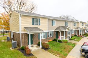 Ashland apartment for rent - a tan house with green shutters and a sidewalk