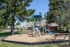 Holland apartment for rent - a playground with a slide and a bench in a park