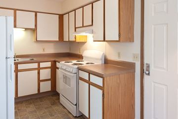 Columbus apartment for rent - a kitchen with white appliances and wooden cabinets