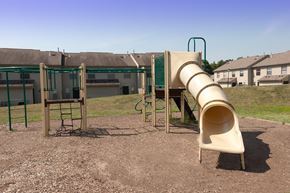 Columbus apartment for rent - a slide at a playground with a house in the background