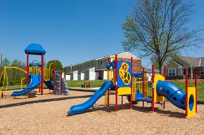 Eminence apartment for rent - a playground with slides and other playground equipment in front of a building