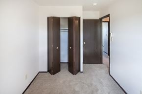 Fostoria apartment for rent - a bedroom with three closet doors and a carpeted floor