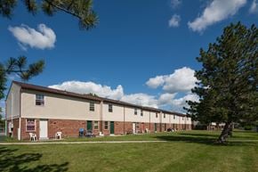 Fostoria apartment for rent - A long building with a green lawn in front.