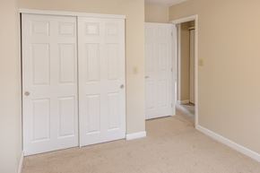 South Point apartment for rent - a bedroom with two closets and a door to a hallway