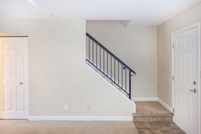 Lawrenceburg apartment for rent - an empty living room with a staircase in a home with white doors