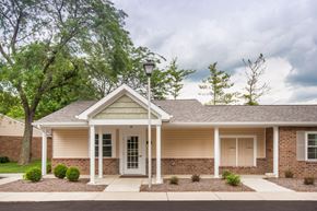 Delaware apartment for rent - the front of a tan house with trees and a street light