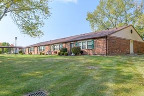 Englewood apartment for rent - the front of a brick building with green grass and trees
