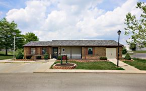 Cambridge apartment for rent - a small brick house with a yard and a sign in front