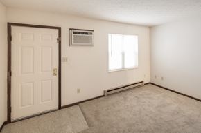 Cambridge apartment for rent - an empty living room with an air conditioner and a white door
