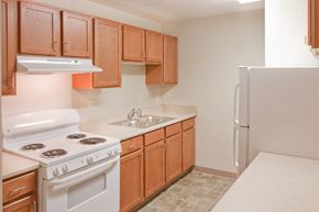 Rushville apartment for rent - a kitchen with white appliances and wooden cabinets