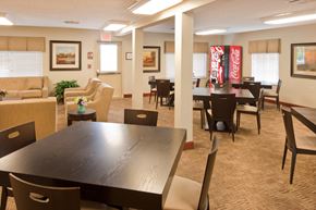 Rushville apartment for rent - a dining room with tables and chairs and a coke vending machine in a lobby