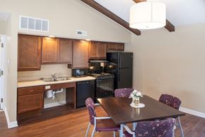 Delaware apartment for rent - a kitchen with black appliances and a dining table with purple chairs