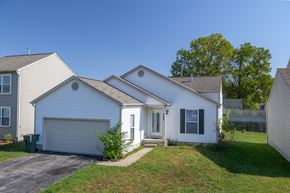 Columbus apartment for rent - a white house with a garage and a lawn