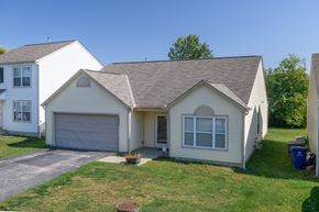 Columbus apartment for rent - the front of a white house with a garage and a lawn