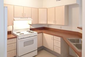Cincinnati apartment for rent - an empty kitchen with white appliances and wooden counters