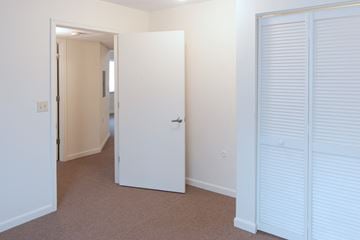 Cincinnati apartment for rent - a bedroom with white closet doors and a door to a hallway